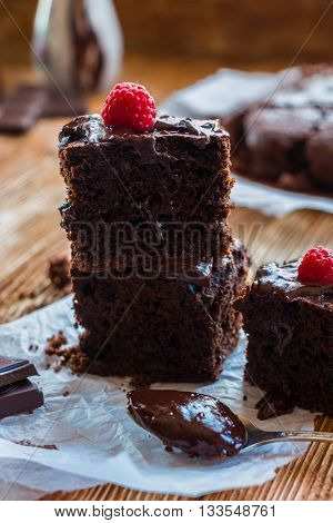 Homemade chocolate brownies with raspberry on the wooden background