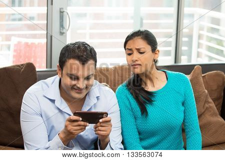 Closeup portrait woman looking sneaky at man texting in secret isolated home house indoors background