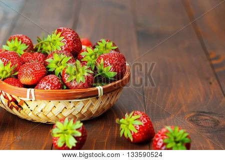 Very Beautiful Background With Fresh Strawberries In A Wicker Round Osier Basket On Old Brown Wooden