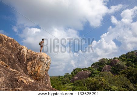 Woman backpacker and photo camera enjoys the beauty of nature hiking in the mountain peak