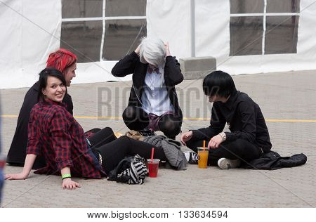 Group Of Visitors Sitting On The Ground At Animefest