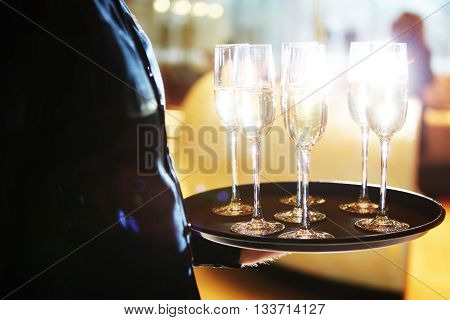 Waiter serving champagne glasses on a tray