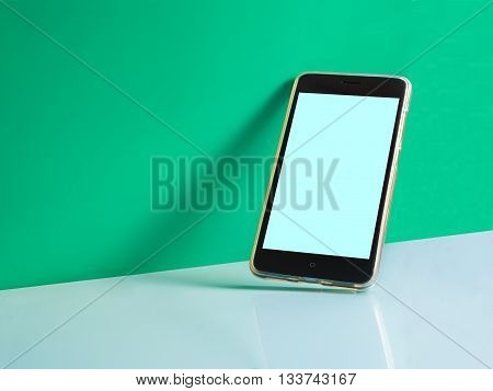 still life shot of smart phone on green cyan background