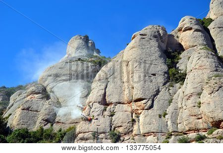 Workmen drilling and securing the limestone of the Mountains of Montserrat, Catalonia, Spain