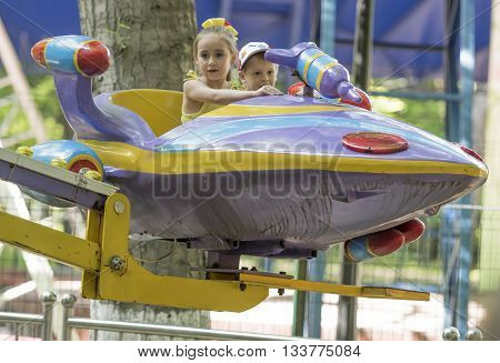 Rostov-on-Don Russia- May 29 2016: Boy and girl with admiration go for a drive on the carousel in the park named after Ostrovsky