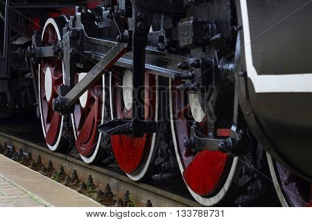 Red wheels of old black steam locomctive