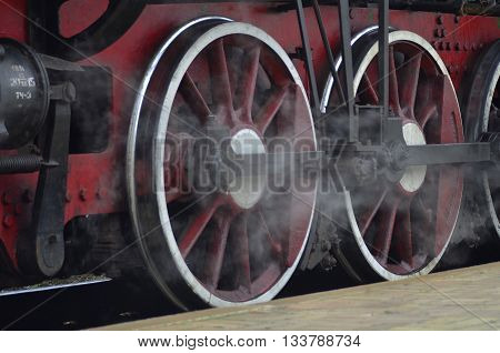 Red wheels of old black steam locomctive
