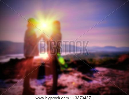 Abstract Blurred and soft photo of the lover standing on the hilltop during sunrise.