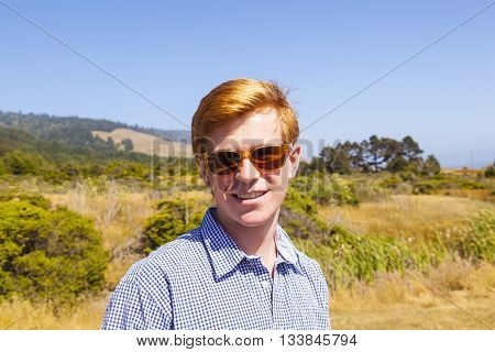 Cool Teenage Boy With Sunglasses Walks Happy On The Meadow