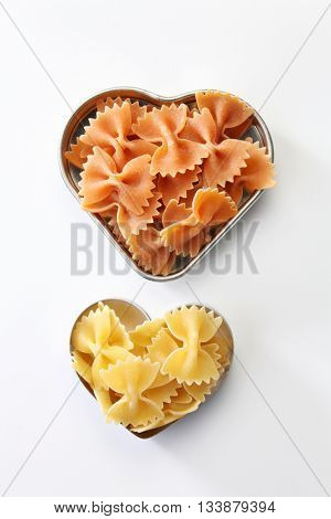 farfalle or farfalloni dry pasta on the heart shape container