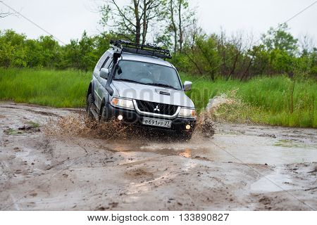 NIKOLAEVKA RUSSIA - JUNE 11 2016: Mitsubishi Pajero moving by water making lots of splashes