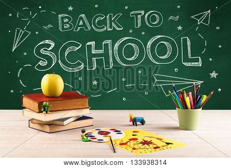 Back to school concepty with writing on blackboard and desk, apple, books, items