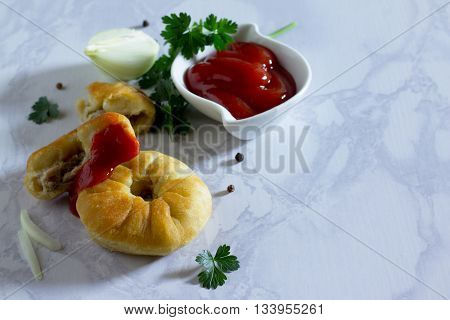 Open Pies With Meat (belyashi) And Tomato Ketchup On A Gray Stone Background.