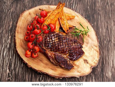 Grilled Beef Sirloin Steak on wooden board with vegetables