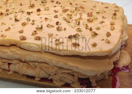 Fragment Of Handmade Cake From A Bise And Nuts On A Wooden Board