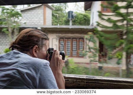 Caucasian Girl Making Photos From Train Window While Treavelling In Sri Lanka. Concept Of Backpacker
