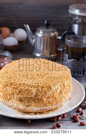 Homemade Honey Cake With Sour Cream On A Wooden Table