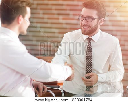 handshake colleagues sitting at your Desk