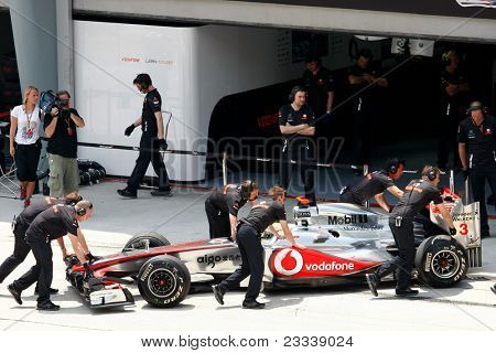 SEPANG, Malajsie - 8. dubna: Mechaniky týmu Mercedes' tlačit Lewis Hamilton vozu zpět do garáže 