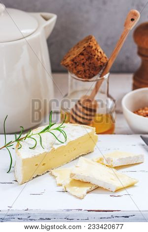 Cheese Plate Served With Crackers, Honey And Nuts. Camembert On White Wood Serving Board Over White 