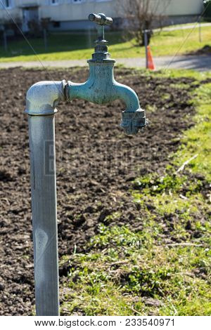 Old Water Pipe Outside, Faucet With Nature Background A Old Rusty Water Tap In Garden.