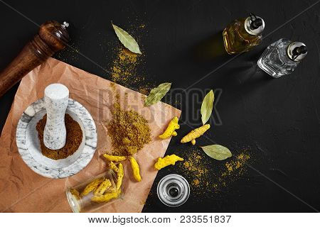 Turmeric Haldi Powder In Small Bowl With Raw Whole In Marble Mortar Over Black Background With Copy 