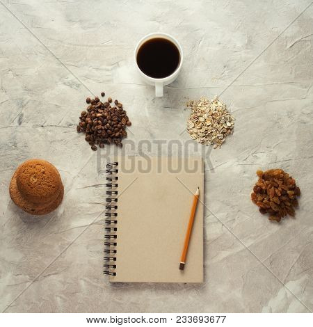 Notebook, Pencil, Biscuits, Oatmeal, Coffee, Raisins And A Cup Of Coffee. Breakfast Concept