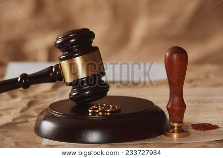 Male Hand Pushing A Wedding Ring Over To A Female Hand About To Sign Divorce Papers. Conceptual Of D