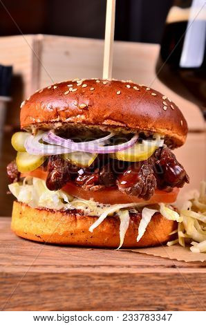 Fresh Homemade Hamburger With Beef, Onion, Sause And Cabbage Garnish And Dark Beer On A Wooden Board
