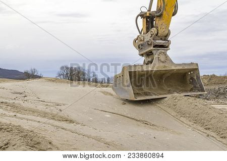 Excavator Shovel On Compressed Loamy Ground At A Construction Site