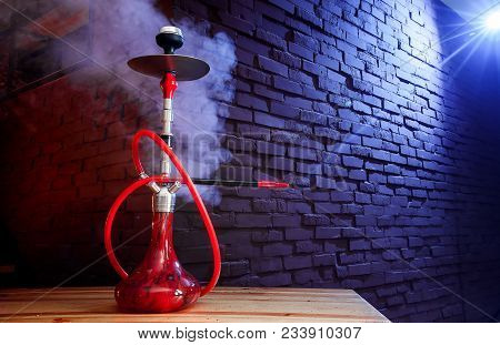 Red Shisha Hookah With Smoke And Red Sparks On Wood Table Brick, Art Background. Shisha Concept