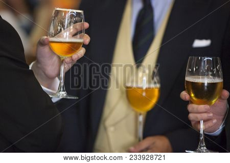 People Drinking Beer At Welcome Cocktail Party With Formal Wear. Three Men With Glass Chalice. Selec