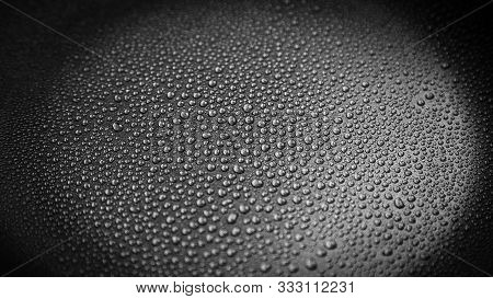 Abstract Background: Many Drops Of Water On A Dark Surface - Non-stick Coating In A Pan. Center In S