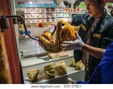 Fenghuang,hunan/china-16 October 2018:unacquainted People Cooking Local Sugar Candy In Souvenir Shop