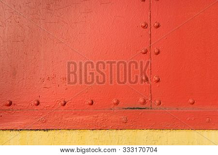 Red And Yellow Vintage Industrial Texture With Symmetrical Horizontal And Vertical Metal Rivets