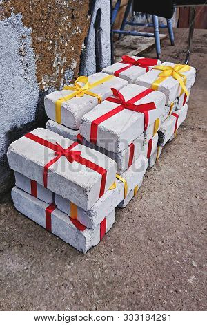 Heap Of White Bricks With Red And Yellow Ribbon As Gift To Christmas Or Birthday, Top View. Christma