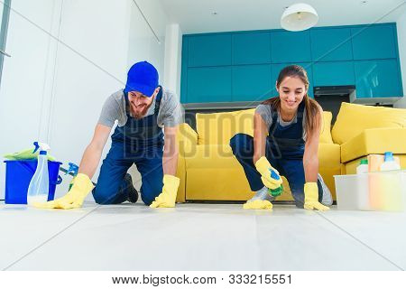 Smiling Girl And Handsome Bearded Man In Workwears Washing The Parquet With The Cleaning Items And W