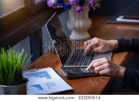 Businesswoman Hand Pressing On Calculator For Calculating Numbers With Laptop. Hand Press Button Use