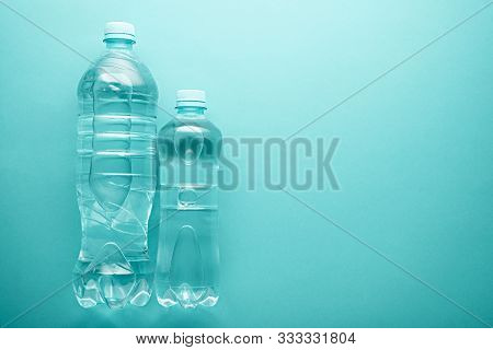 Top View Large And Small Plastic Clean Pure Water Bottles With Copy Space On Neo Mint Background