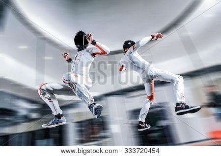 Fly Men. Skydiving Team Of Flying People In Wind Tunnel . Indoor Skydiving