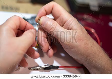 A Man Is Repairing An Led That He Holds In His Hands