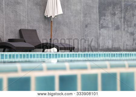 Chair And Umbrella Set Beside The Swimming Pool.