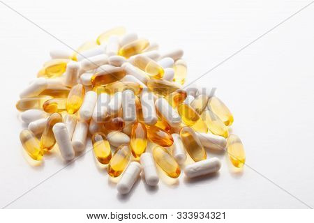 Tablets, Pills, Capsules, Drugs Pouring Out Of White Bottle On White Background. Sport, Healthy Life
