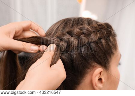 Professional Stylist Braiding Client's Hair In Salon, Closeup