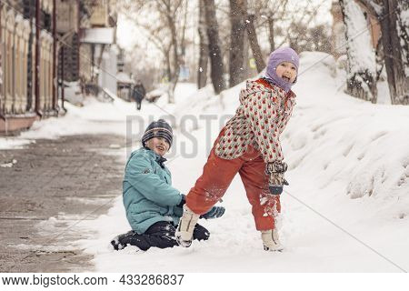 26th Of March 2021, Russia, Tomsk: Kids Throwing Snowballs At The Street In Winter