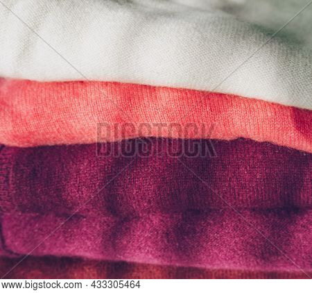 Close Up View Of Stack Of White To Dark Magenta Cachemire Clothes