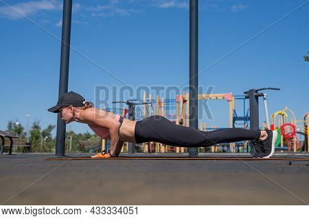 Sportive Woman Working Out On The Sports Ground In Sunny Summer Day