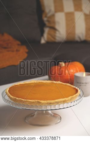Pumpkin And Concrete Candlestick On Table In Living Room Next To Sofa With Pillows And Blanket. Autu