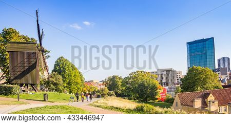 Aarhus, Denmark - September 01, 2021: Panorama Of The Wooden Windmill And The Modern Skyline Of Aarh