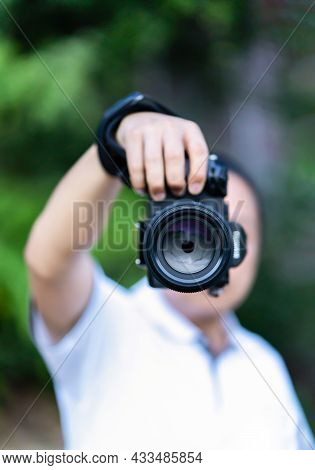 Asian Man Holds The Medium Format Camera In His Hand And Focus To Shoot In Front Of Him.